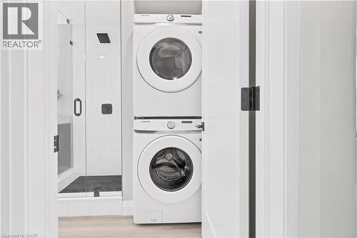 Stacked laundry appliances in a dedicated alcove, featuring a white finish and visible controls - 71 Blucher Street Unit# G, Kitchener, ON 