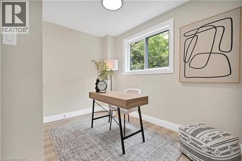 Room featuring light wood-finish flooring, a contemporary overhead light fixture, and a window with white trim - 71 Blucher Street Unit# G, Kitchener, ON 