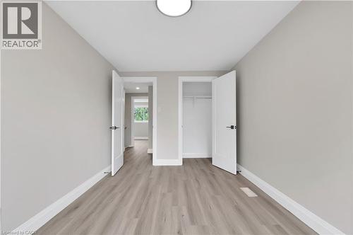 Neutrally painted room featuring wood-finish flooring, white trim, and recessed lighting - 71 Blucher Street Unit# G, Kitchener, ON 