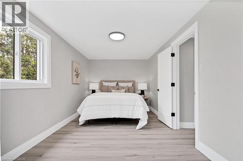 Bedroom featuring light wood-finish flooring, crisp white baseboards, and a single pane window with white trim - 71 Blucher Street Unit# G, Kitchener, ON 