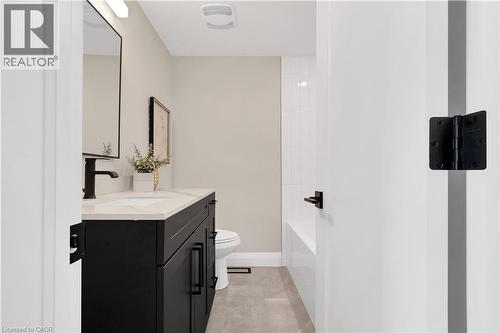 Bathroom featuring a dark wood vanity with a white countertop, undermount sink, and matte black faucet - 71 Blucher Street Unit# G, Kitchener, ON 