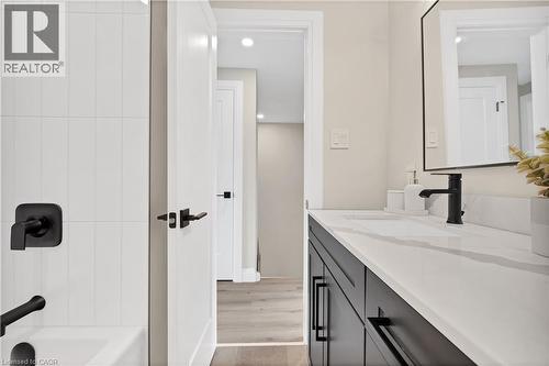 Bathroom featuring a dark wood-finish vanity with a white countertop and integrated sink - 71 Blucher Street Unit# G, Kitchener, ON 