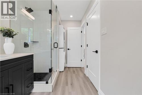 Modern bathroom featuring a glass-enclosed shower with a rainfall showerhead and black hardware - 71 Blucher Street Unit# G, Kitchener, ON 