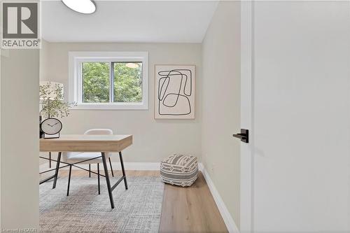 Bright room with a large window, light wood-finish flooring, and a modern white door with matte black hardware - 71 Blucher Street Unit# G, Kitchener, ON 