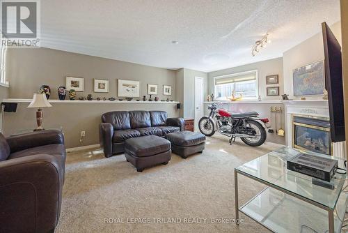 Lower family room with above grade windows - 17 - 1100 Byron Baseline Road, London South (South K), ON - Indoor Photo Showing Living Room With Fireplace