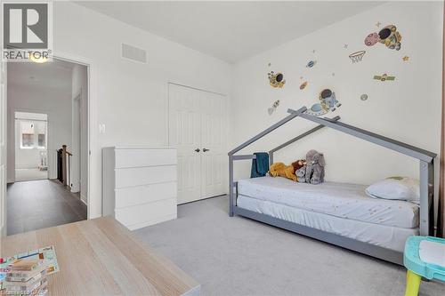 Bedroom3- Carpeted room with a double-door closet, white walls, and an open doorway leading to a hallway with wood-finish flooring - 101 Westfield Crescent, Waterdown, ON 