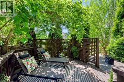 Wood-finish deck with privacy lattice fencing and lush surrounding foliage - 