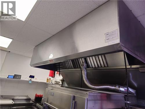 Commercial-grade stainless steel exhaust hood with integrated baffling and ventilation system, installed above a stainless steel cooking appliance - 71 Ross Street Unit# 2, St. Thomas, ON 