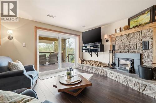 Living area featuring rich wood-finish flooring and a stone-clad fireplace with a wood-burning insert - 5258 Cedar Springs Road, Burlington, ON - Indoor Photo Showing Living Room With Fireplace