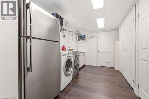 Laundry area featuring wood-finish flooring, recessed lighting, and ample storage cabinetry - 5258 Cedar Springs Road, Burlington, ON - Indoor Photo Showing Laundry Room