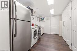Laundry area featuring wood-finish flooring, recessed lighting, and ample storage cabinetry - 