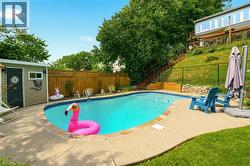 Curved inground pool with concrete surround and stone coping - 