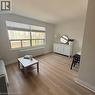 Spacious interior featuring wide-plank wood-finish flooring, a large window with blinds, and white baseboards - 57 Mericourt Road Unit# 111, Hamilton, ON  - Indoor Photo Showing Living Room 