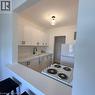 Kitchen featuring white cabinetry with black hardware, stone-look countertops, a black gooseneck faucet, an integrated sink, and an electric range - 57 Mericourt Road Unit# 111, Hamilton, ON  - Indoor Photo Showing Kitchen 