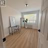 Bright room featuring wood-finish flooring, a large window with blinds, and a ceiling-mounted light fixture - 57 Mericourt Road Unit# 111, Hamilton, ON  - Indoor 