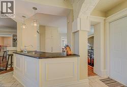 Kitchen island with a dark countertop and undermount sink, illuminated by two clear glass pendant lights - 