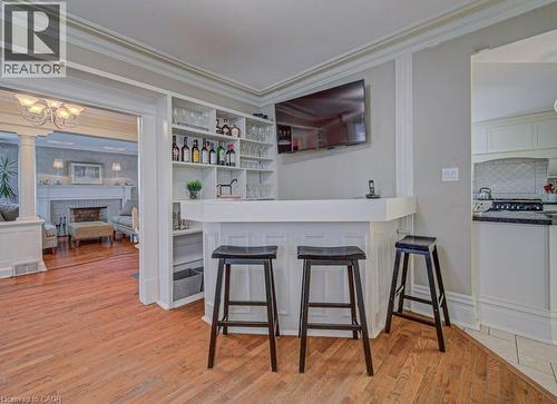 Built-in bar featuring integrated open shelving, panel detailing, and a wall-mounted display - 2032 Coronation Boulevard, Cambridge, ON - Indoor Photo Showing Other Room