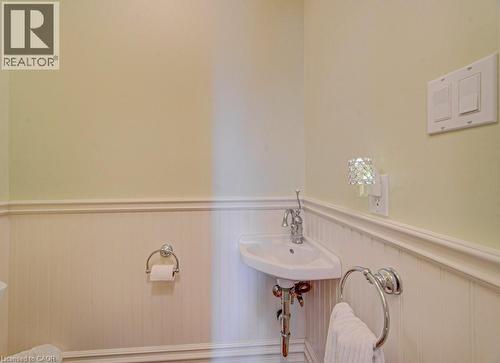 Corner pedestal sink with chrome faucet, beadboard wainscoting, and decorative wall trim - 2032 Coronation Boulevard, Cambridge, ON - Indoor Photo Showing Bathroom