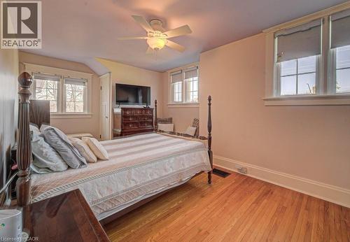 Hardwood flooring throughout featuring multiple windows with white trim and a ceiling fan with integrated lighting - 2032 Coronation Boulevard, Cambridge, ON - Indoor Photo Showing Bedroom