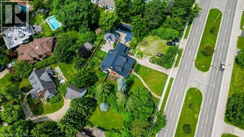 Aerial perspective showcasing a residential property with surrounding mature trees, expansive green spaces, and a paved road - 2032 Coronation Boulevard, Cambridge, ON - Outdoor With View