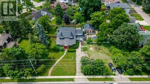 Traditional-style property featuring a prominent red brick facade with dark roof shingles and dormer windows - 2032 Coronation Boulevard, Cambridge, ON - Outdoor