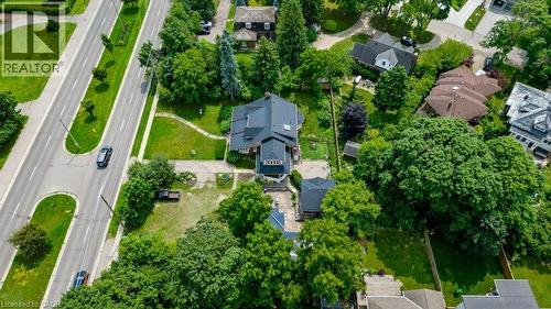 Expansive property featuring a substantial residence with a dark roof, surrounded by mature trees and manicured green spaces - 2032 Coronation Boulevard, Cambridge, ON - Outdoor With View