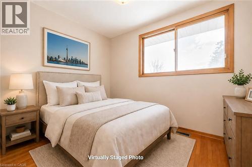 Room featuring wood-finish flooring, a neutral wall color, and a large window with wood trim - 66 Summit Avenue, Kitchener, ON - Indoor Photo Showing Bedroom
