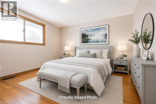 Bedroom featuring wood-finish flooring, a neutral color palette, and a substantial window with wood-finish trim - 66 Summit Avenue, Kitchener, ON - Indoor Photo Showing Bedroom
