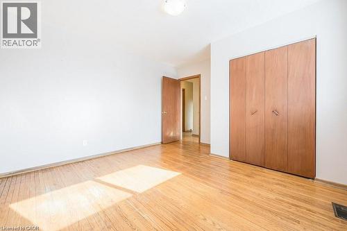 Hardwood flooring extends throughout this room, featuring a built-in closet with double bifold doors - 66 Summit Avenue, Kitchener, ON - Indoor Photo Showing Other Room