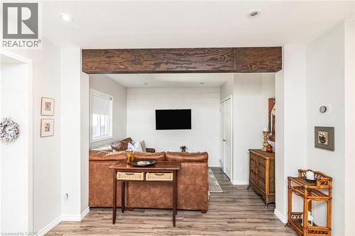 Open concept living space featuring a prominent wood beam accent, recessed lighting, and wood-finish flooring - 134 Erie Avenue, Hamilton, ON 