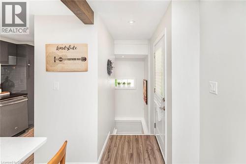 Contemporary entryway featuring wood-finish flooring, recessed lighting, and a white paneled door with louvered glass - 134 Erie Avenue, Hamilton, ON 