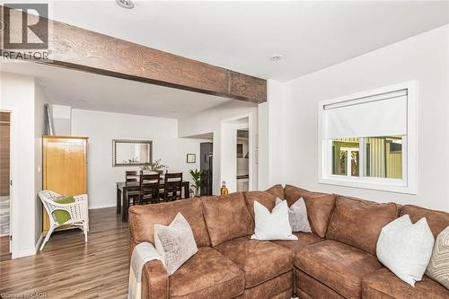 Open-concept living space featuring exposed wood beam accents, wood-finish flooring, recessed lighting, and a dining area - 134 Erie Avenue, Hamilton, ON 