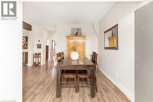 Dining area featuring wood-finish flooring, white baseboards, and neutral wall tones - 134 Erie Avenue, Hamilton, ON 