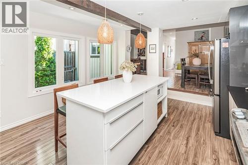 Kitchen island featuring a white countertop, integrated storage, and an open shelf - 134 Erie Avenue, Hamilton, ON 