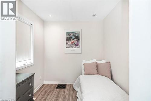 Room featuring wood-finish flooring, recessed lighting, and a window with roller blinds - 134 Erie Avenue, Hamilton, ON 