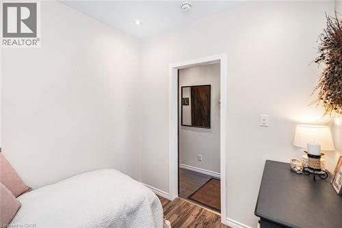 Minimalist room featuring recessed ceiling lighting, wood-finish flooring, and crisp white wall paint - 134 Erie Avenue, Hamilton, ON 