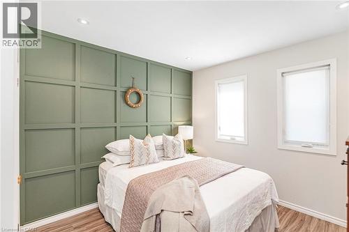 Accent wall with grid paneling, recessed lighting, two windows with roller shades, and wood-finish flooring - 134 Erie Avenue, Hamilton, ON 
