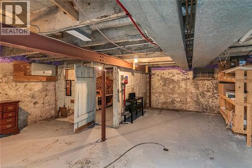 Spacious basement area featuring a concrete floor, exposed ceiling joists, and a partial stone foundation - 134 Erie Avenue, Hamilton, ON 