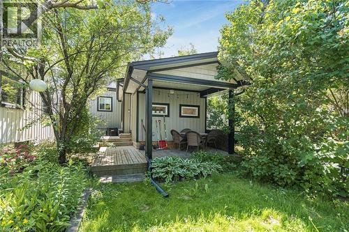Covered outdoor patio area featuring a wooden deck, slatted siding, and recessed lighting - 134 Erie Avenue, Hamilton, ON 
