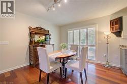 Hardwood flooring featuring an adjacent glass-paneled door with plantation shutters and a track lighting fixture - 