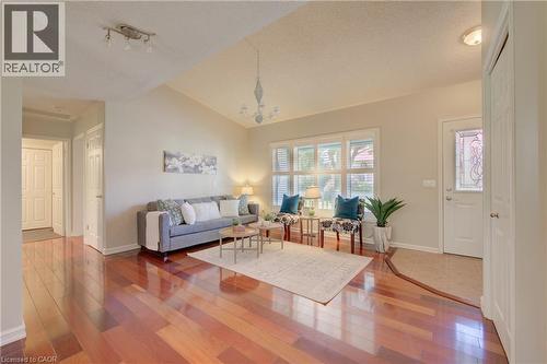 Spacious living area featuring polished wood-finish flooring and a vaulted ceiling - 137 Wesley Crescent, Waterloo, ON 