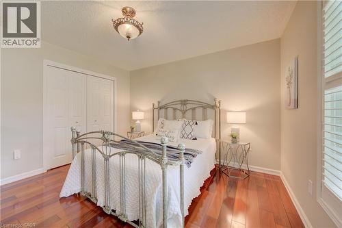 Bedroom featuring wood-finish flooring, neutral wall tones, and crown molding - 137 Wesley Crescent, Waterloo, ON 