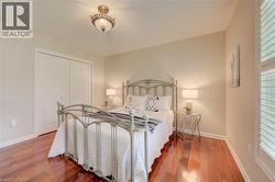 Bedroom featuring wood-finish flooring, neutral wall tones, and crown molding - 