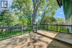 Expansive wooden deck featuring dark-stained railings with decorative balusters - 