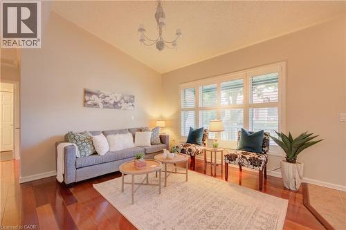 Living area featuring vaulted ceilings, wood-finish flooring, and a multi-pane window with louvered blinds - 137 Wesley Crescent, Waterloo, ON 