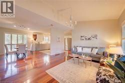 Open-concept living area with lustrous wood-finish flooring - 