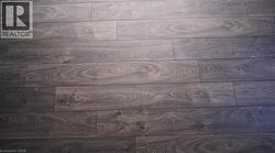 Dark wood-finish flooring with visible grain and varied plank lengths - 