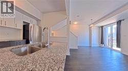 Kitchen featuring granite countertops, undermount double-basin sink, and stainless steel appliances - 