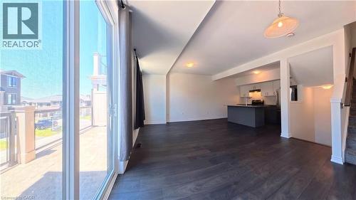 Open concept living space featuring dark wood-finish flooring, a modern pendant light fixture, and recessed lighting - 10 Birmingham Drive Unit# 129, Cambridge, ON - Indoor Photo Showing Other Room