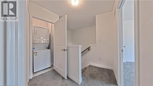 Integrated laundry closet with stacked appliances - 10 Birmingham Drive Unit# 129, Cambridge, ON - Indoor Photo Showing Laundry Room
